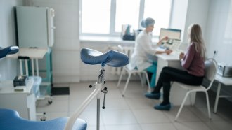 A gynecologist and a patient sit at a desk reviewing medical results.
